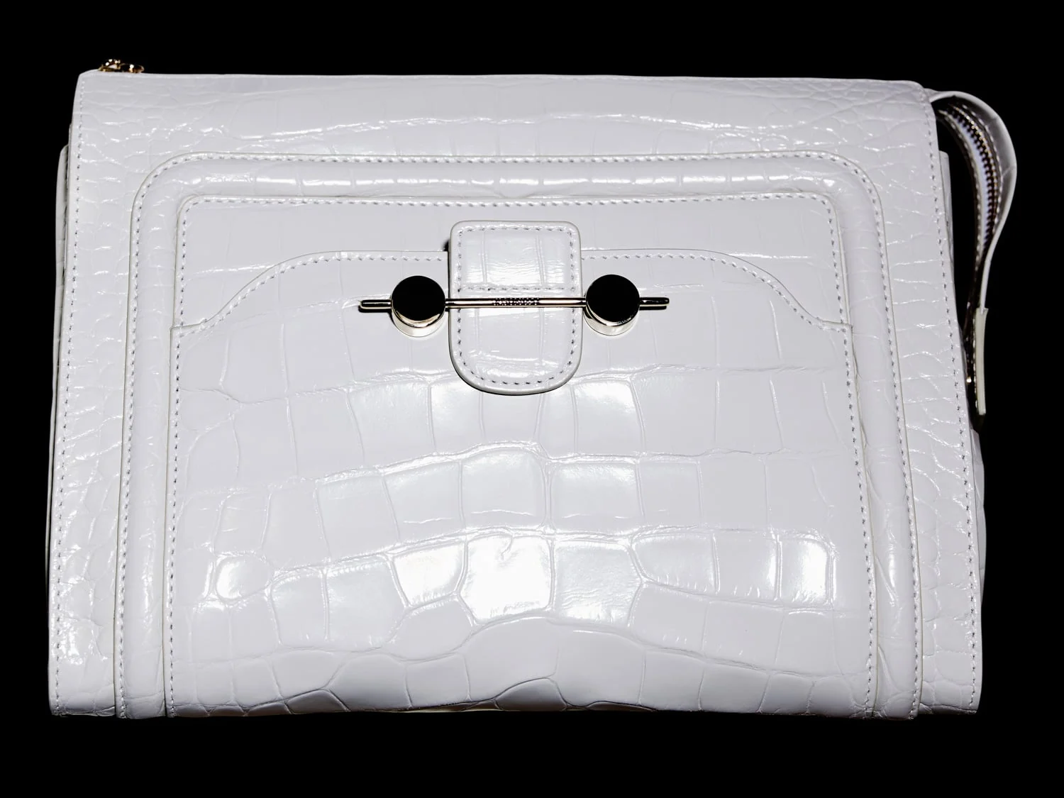White croc-embossed leather clutch with a silver bar clasp and wrist strap on a black background, for Jason Wu.