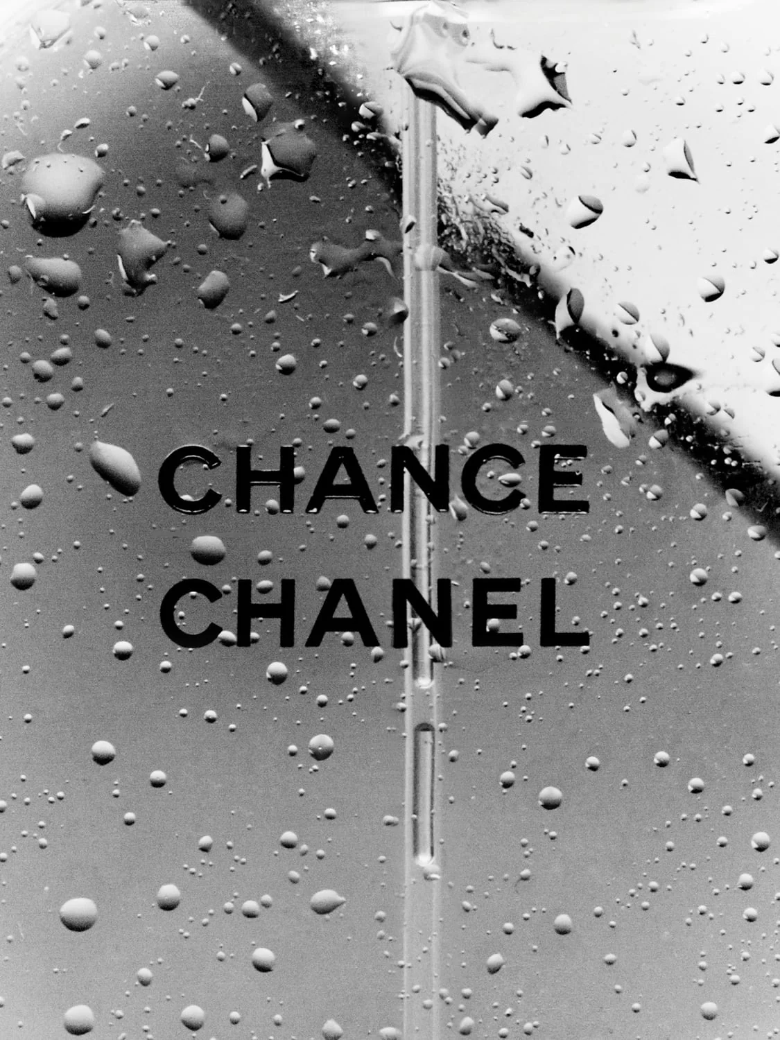 Close-up of a Chance perfume bottle covered in water droplets, in black and white, for Chanel.
