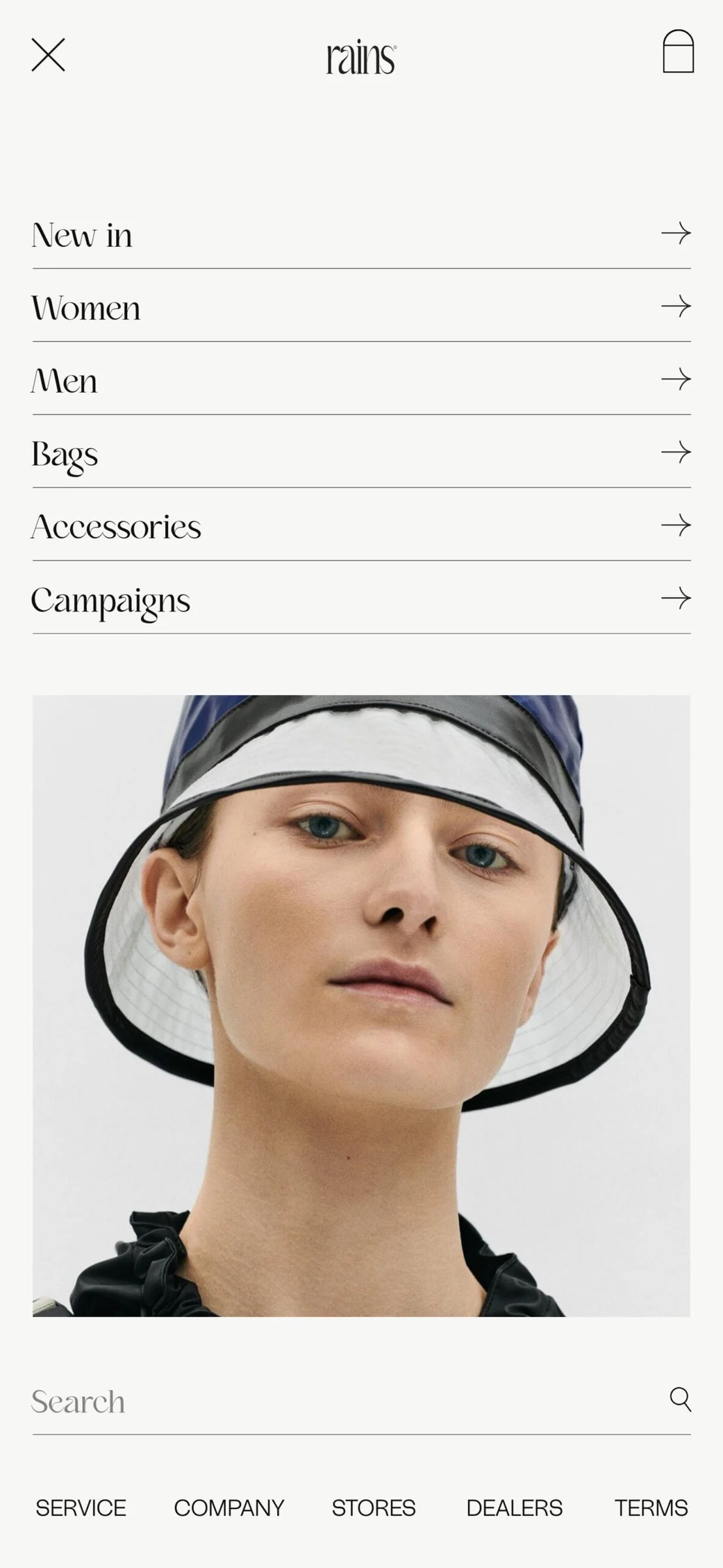 Mobile website menu with a model in a navy and white bucket hat below the navigation links, for Rains.