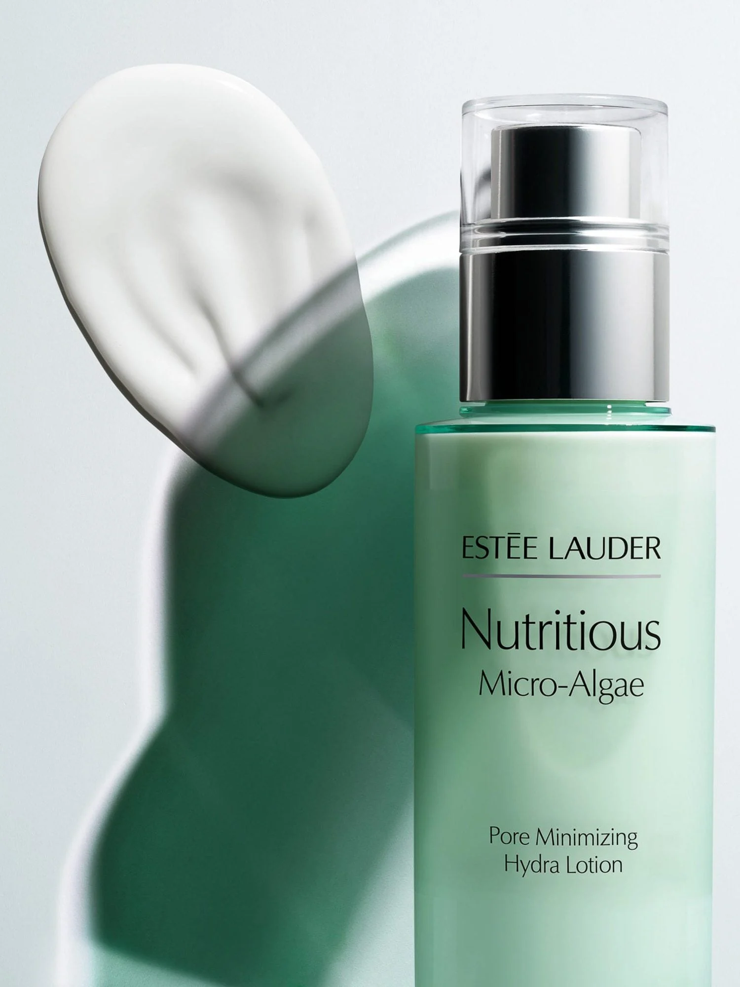 Mint-green Nutritious Micro-Algae lotion bottle with silver pump beside a white cream swatch and green shadow, for Estée Lauder.